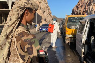 Members of Yemen’s separatist Southern Transitional Council staff a checkpoint while workers disinfect vehicles at the entrance of Mualla, a district of the southern province of Aden, on May 10, 2020. AFP