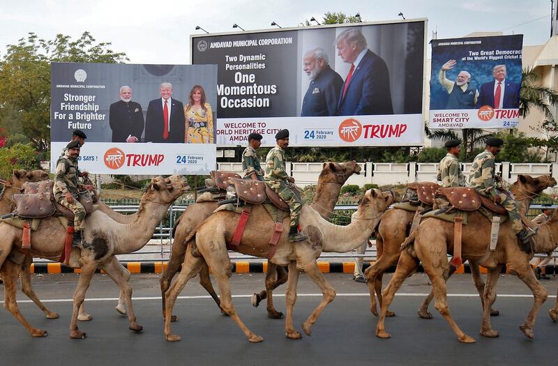 Border Security Force soldiers ride their camels past hoardings with the images of India's Prime Minister Narendra Modi in Ahmedabad, India. Reuters