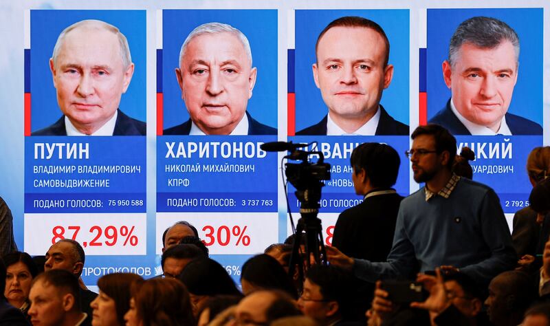 Officials and journalists gather near a screen showing the preliminary results of Russia's presidential election in Moscow. Reuters