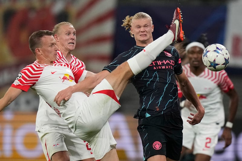 Manchester City's Erling Haaland, right, fights for the ball with Leipzig's Lukas Klostermann during their Champions League match in Leipzig, Germany. AP