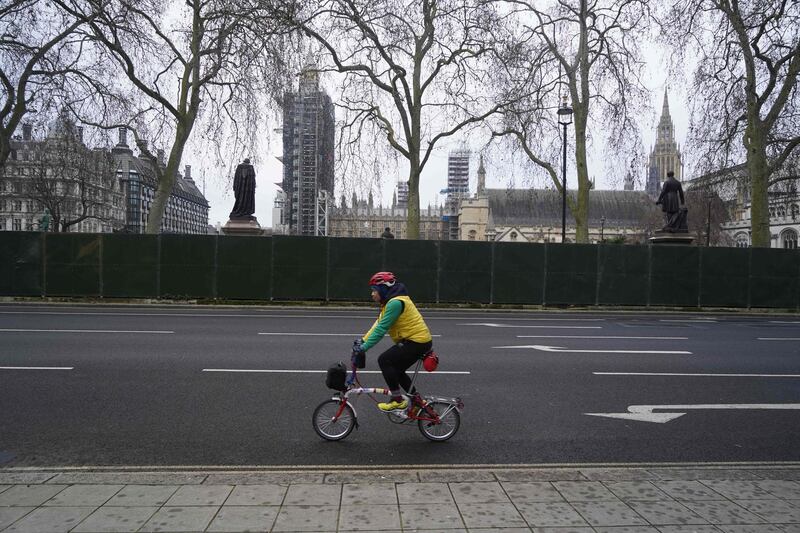 A cyclist passes fencing in Parliament Square outside the Houses of Parliament in central London. AFP