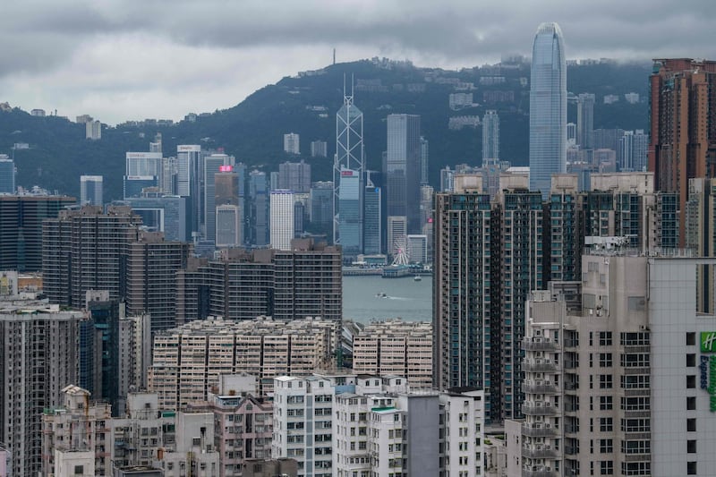 This picture taken on August 3, 2019 shows a general view of residential and commercial buildings in the Kowloon district (foreground) with the skyline of Hong Kong Island past Victoria Harbour (C) in the distance. / AFP / ANTHONY WALLACE
