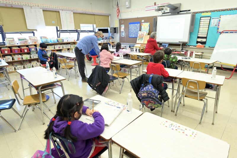 Binasa Musovic (left), an educational paraprofessional and Chris Frank, a teacher at Yung Wing School P.S. 124, teach blended learning students during the first day back to school in New York City.  AFP