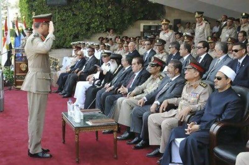 An Egyptian military officer salutes president Mohammed Morsi, third from right, at a military graduation ceremony in Cairo.