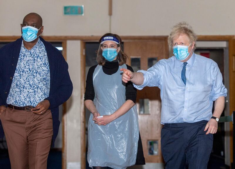 Britain's Prime Minister Boris Johnson (R) visits to a Covid-19 vaccination centre at a church, Jesus House for All The Nations, in Brent, north London on March 7, 2021. / AFP / POOL / Geoff Pugh
