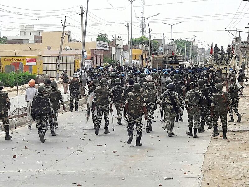 Indian paramilitary personnel walk towards the 'Dera Sacha Sauda' Ashram in Sirsa on August 26, 2017, after followers of controversial guru Ram Rahim Singh on August 25 went on a rampage after their spiritual leader was convicted of rape.  
Hundreds of troops on August 25 patrolled a northern Indian city hit by deadly clashes that killed at least 30 people after thousands protested a court's decision to convict a controversial spiritual leader of rape. / AFP PHOTO / -