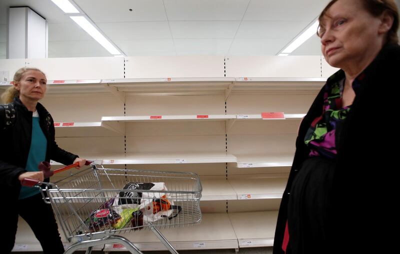 Customers walk next to empty shelves at a Sainsbury's store in Harpenden. Reuters