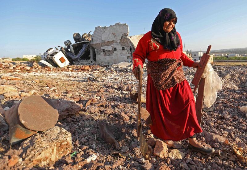 TOPSHOT - A woman salvages items from a building that was reportedly destroyed during airstrikes by the Syrian regime ally Russia, in the town of Kafranbel in the rebel-held part of the Syrian Idlib province on May 20, 2019.  According to a war monitor, air strikes by regime ally Russia resumed on the Idlib region late yesterday, after shelling and rocket fire by regime forces earlier in the day killed six civilians.
  / AFP / OMAR HAJ KADOUR

