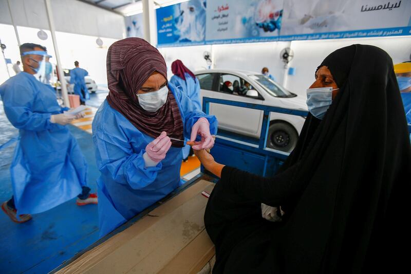 A healthcare worker collects blood samples from passengers at a coronavirus disease (COVID-19) drive-thru testing center in the holy city of Najaf, Iraq, July 16, 2020. REUTERS/Alaa Al-Marjani