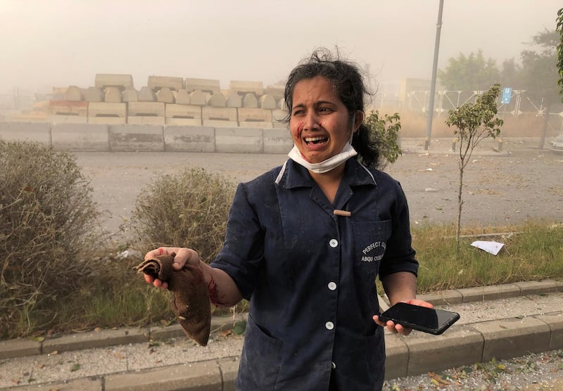 A migrant worker reacts in shock following an explosion at the Beirut port.  EPA