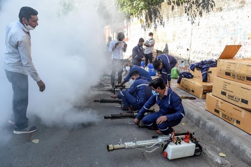 Workers test new thermal fogging machines used against mosquitoes and various diseases including the Covid-19 on a street in Ahmedabad, India. AFP