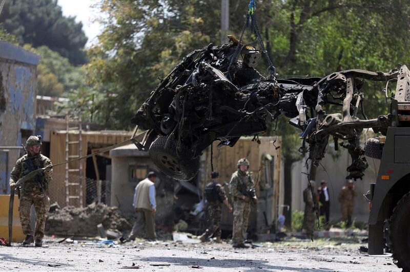Resolute Support (RS) forces and Afghan security personnel clear debris at the site of a car bomb explosion in Kabul, Afghanistan, Thursday, Sept. 5, 2019. A car bomb rocked the Afghan capital on Thursday and smoke rose from a part of eastern Kabul near a neighborhood housing the U.S. Embassy, the NATO Resolute Support mission and other diplomatic missions. (AP Photo/Rahmat Gul)