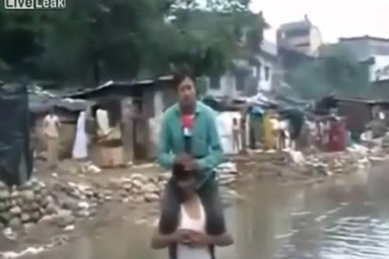  A screengrab from live reporting of Narayan Pargaien, during the flash floods and landslides in Uttarakhand state, triggered outrage after a video clip went viral on the internet showing him speaking into the camera while sitting on the shoulders of a local villager. 