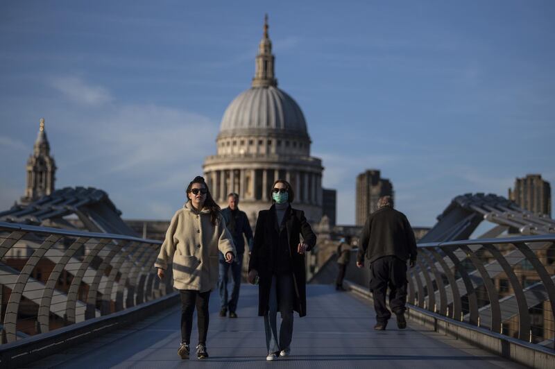 A woman crosses the millennium bridge in front of St Paul's Cathedral wearing a face mask for protection against the coronavirus on March 16, 2020 in London, England. Getty Images