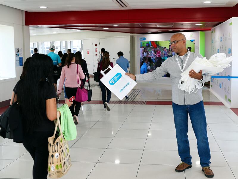 Dubai, United Arab Emirates - August 19th, 2017: Mohamed Sultan from International humanitarian city hands out reusable bags on World Humanitarian Day where 150 photos are displayed that reflect the suffering of the peoples of the countries most affected by famines, epidemics, natural disasters and political conflicts. Saturday, August 19th, 2017 at Mall of the Emirates metro, Dubai. Chris Whiteoak / The National
