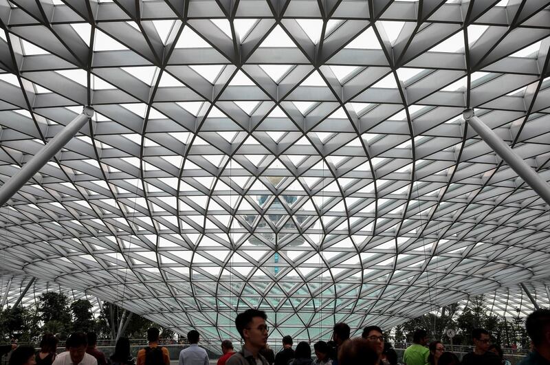 People walking underneath the facade of Jewel Changi.  EPA