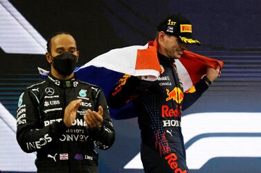 FILE PHOTO: Formula One F1 - Abu Dhabi Grand Prix - Yas Marina Circuit, Abu Dhabi, United Arab Emirates - December 12, 2021 Red Bull's Max Verstappen celebrates winning the race and the world championship with the Netherlands flag on the podium as Mercedes' Lewis Hamilton looks on after finishing second REUTERS / Hamad I Mohammed / File Photo