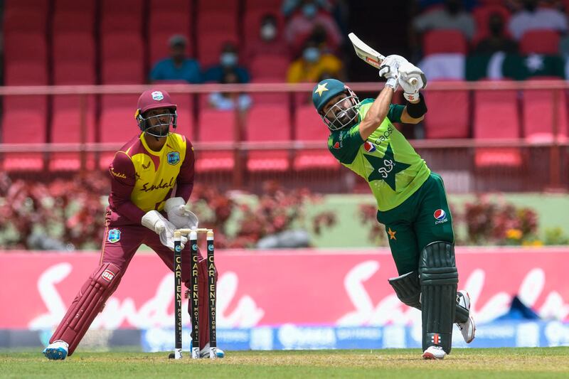 Mohammad Rizwan (R) of Pakistan hits 6 and Nicholas Pooran (L) of the West Indies looks on during the 3rd T20I match between the West Indies and Pakistan at Guyana National Stadium in Providence, Guyana, on July 31, 2021 (Photo by Randy Brooks  /  AFP)