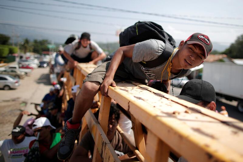 Migrants, part of a caravan of thousands from Central America en route to the United States, hitchhike on a truck along the highway to Arriaga from Pijijiapan, Mexico, October 26, 2018. REUTERS/Ueslei Marcelino