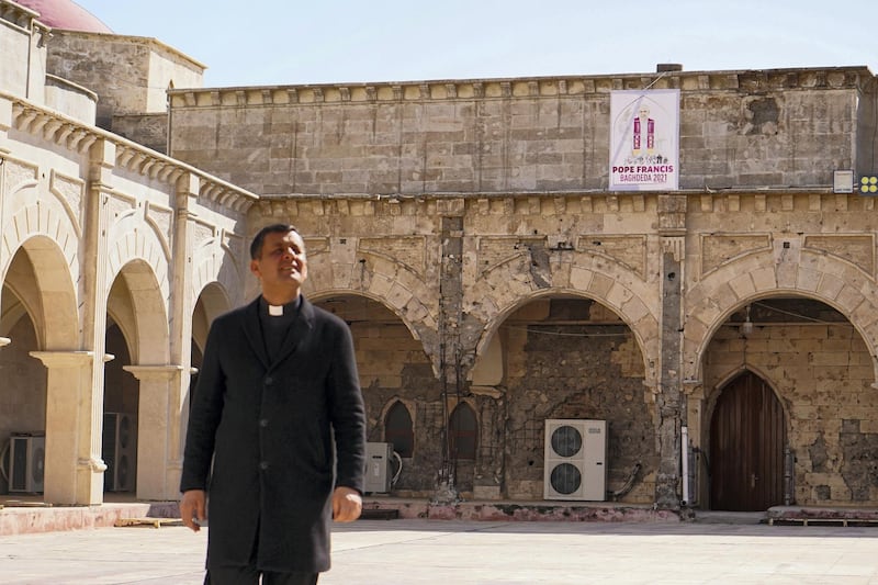 QARAQOSH, IRAQ - 2021/02/25: Father Ammar Yako, the head of the church, walks past a poster of Pope Francis days before his historic visit to Iraq.
The town of Qaraqosh, 30 kilometres southeast of the city of Mosul, is preparing to reception Pope Francis by renovating the church that the Pope will visit and by decorating the streets with the Vatican flags and pictures of the Pope on his first and historical visit to Iraq from March 5-8, his historical visit includes a trip to several cities, including the capital Baghdad, the city of Mosul in north and a meeting with the Shiite religious authority Ayatollah Ali Sistani. (Photo by Ismael Adnan/SOPA Images/LightRocket via Getty Images)