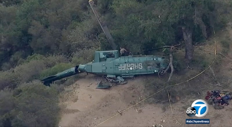 This ABC7 Los Angeles aerial video image shows emergency personnel next to a Sheriff Department helicopter after it crashed in Azusa, California.  AP Photo