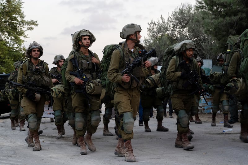 Israeli soldiers walk through Kibbutz Be'eri. Days earlier Hamas militants killed more than a hundred civilians near the border with Gaza. Getty Images