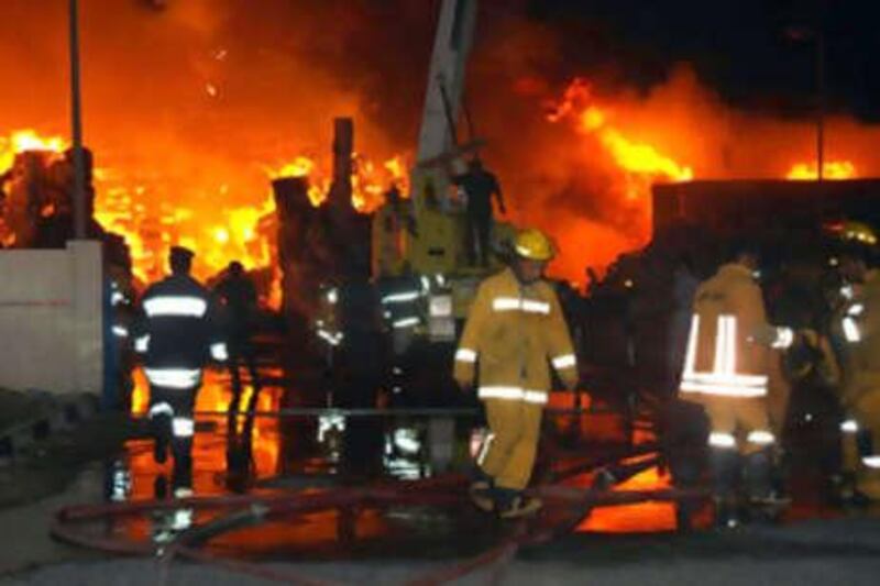 31 AUGUST 2008: ABU DHABI, UAE: Emergency services are seen dousing the twisted, smouldering remains of two factories gutted by a fierce blaze that injured eleven firefighters. 
The fire broke out at a paper mill in the industrial area of Musaffah, and spread to a nearby carpet factory, according to a statement from Abu Dhabi police. Firefighters, who were on the scene withing five minutes, worked through the night to control the inferno and prevent it from spreading further. (C) Abu Dhabi Police           