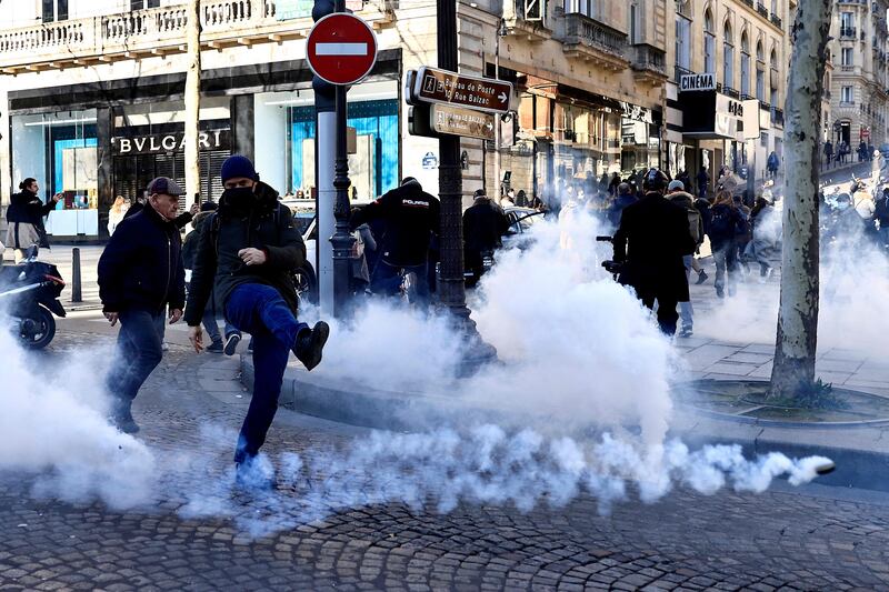 Tear gas is fired by French riot police on the Champs Elysees in Paris on Saturday in an effort to break up demonstrations against coronavirus regulations. Photo: AFP