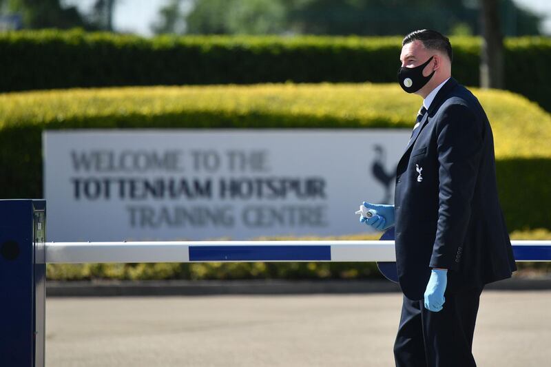 A security guard wearing a face mask patrols at the entrance to the Tottenham training ground in north London. AFP