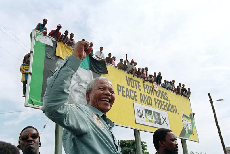 African National Congress (ANC) President Nelson Mandela greets young supporters who wait for atop a billboard in a township outside Durban, 16 April 1994 prior to an election rally. South Africans will vote 27 April 1994 in the country's first democratic and multiracial general elections.