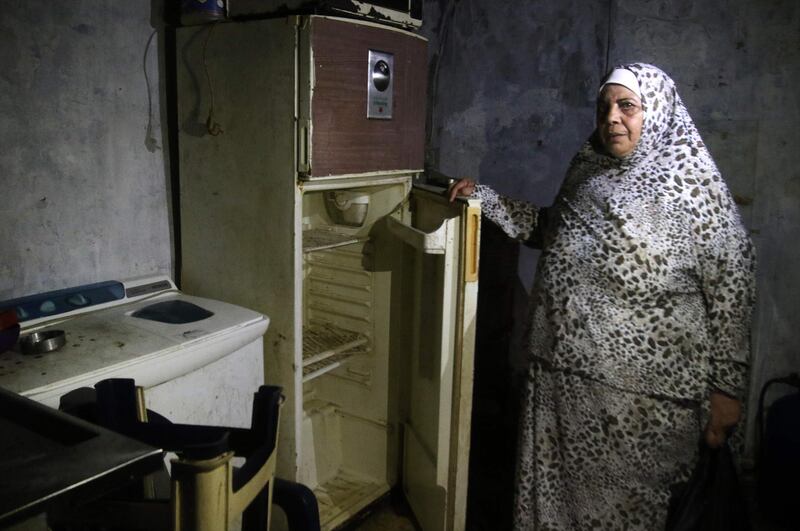 A Lebanese woman displays the content of her refrigerator at her apartment in the southern city of Sidon. AFP