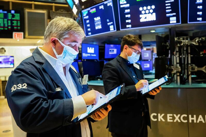 In this photo provided by the New York Stock Exchange, a pair of traders work on the floor, Tuesday Feb. 2, 2021. Stocks were broadly higher in afternoon trading Tuesday, but shares of closely watched companies like GameStop and AMC Entertainment were falling sharply. (Colin Ziemer/New York Stock Exchange via AP)