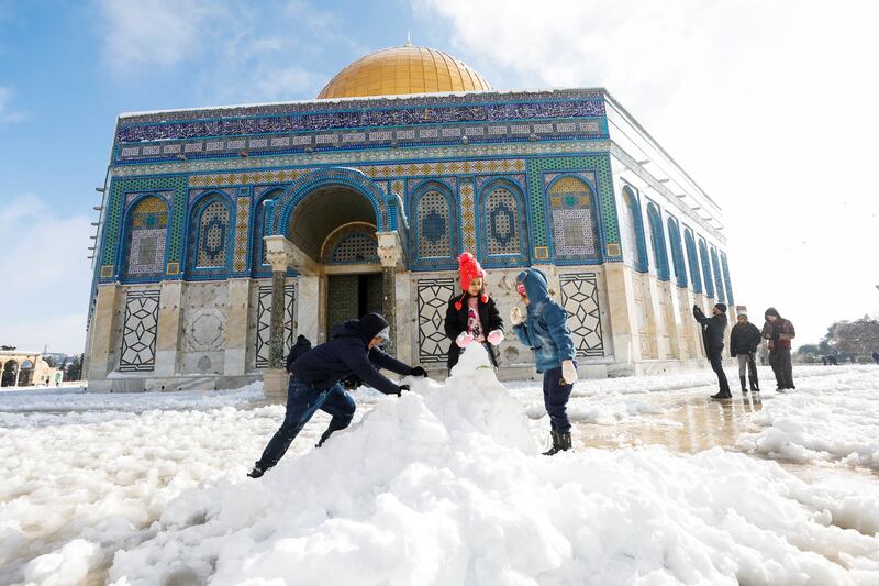 Children build a snowman in front of the Dome of the Rock. Reuters