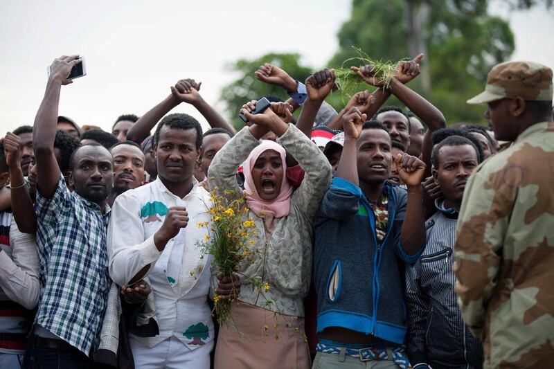 Residents of Bishoftu crossing their wrists above their heads as a symbol for the Oromo anti-government protest movement during the Oromo new year holiday Irreechaa in Bishoftu. Ethiopia declared a state of emergency on October 9, 2016 following months of violent anti-government protests. AFP / Zacharias ABUBEKER

