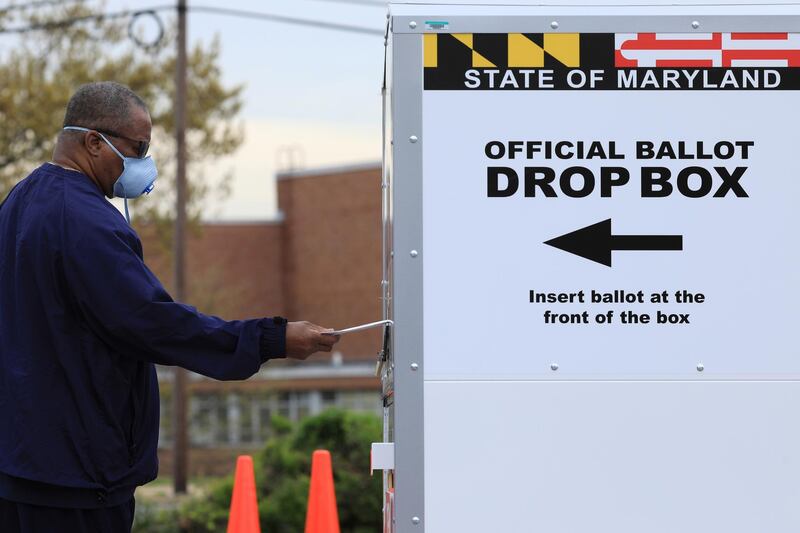 FILE PHOTO: A resident drops off a mail-in ballot at the Edmondson Westside High School Polling site in Baltimore, Maryland, U.S., April 28, 2020. REUTERS/Tom Brenner/File Photo