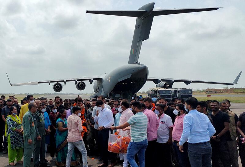 Indian diplomatic staff and their families gather on the runway after their flight from Kabul lands in Jamnagar, western Gujarat state, on its way to Delhi. Reuters