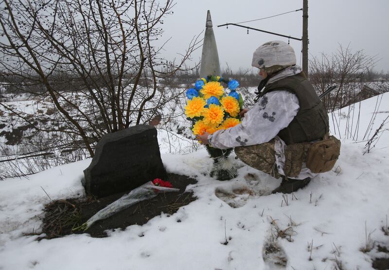 A Ukrainian serviceman lays flowers where one of his friends was killed in 2017 near Avdiivka. Anatolii Stepanov / AFP