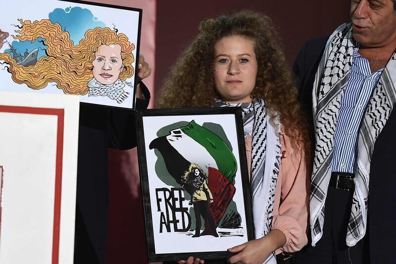 Palestinian activist and campaigner Ahed Tamimi displays a painting she received while attending the Greek Communist Party Youth festival in Athens as a special guest. AFP