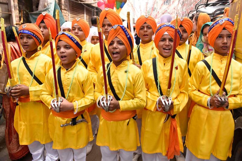Youth Sikh devotees hold swords as they participate in a "Nagar Kirtan" (holy procession) on the eve of the 550th birth anniversary of Sikhism founder Sri Guru Nanak Dev, at the Golden Temple in Amritsar.  AFP