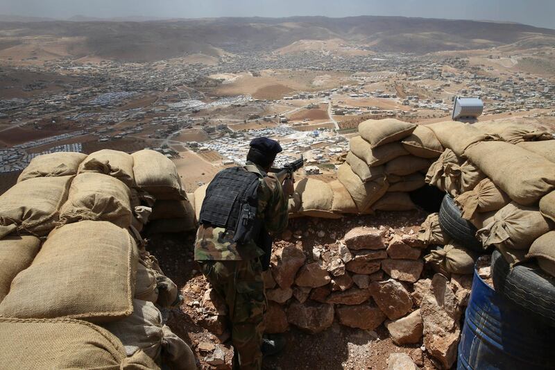 FILE -- In this June 19, 2016 file photo, a Lebanese army soldier takes his position overlooking an area controlled by the Islamic State group at the edge of the town of Arsal, in northeast Lebanon. Lebanonâ€™s U.S.-backed military is gearing up for a long awaited assault to dislodge hundreds of IS militants from a remote corner of northeastern Lebanon near the border with Syria, seeking to end a years-long threat posed to neighboring towns and villages by the extremists. (AP Photo/Hussein Malla, File)