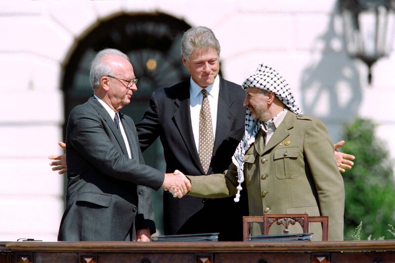 US president Bill Clinton stands between PLO leader Yasser Arafat and Israeli prime minister Yitzhak Rabin as they shake hands for the first time, on September 13, 1993. AFP