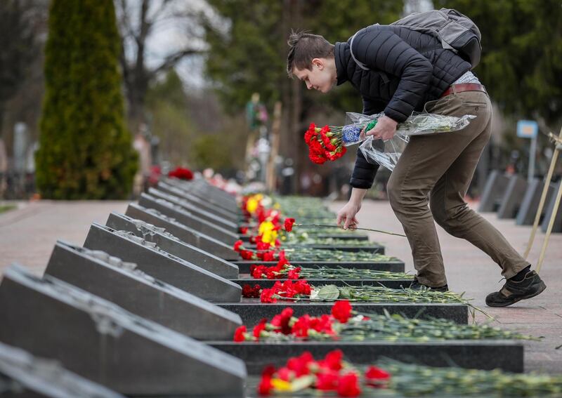 epa09161782 A man places flowers at the tombs of the victims of the Chernobyl nuclear power plant disaster at the Mitino cemetery in Moscow, Russia, 26 April 2021, on the 35th anniversary of the tragedy. The explosion of reactor 4 of the Chernobyl nuclear power plant in the early hours of 26 April 1986 is still regarded as the worst nuclear disaster to date.  EPA/YURI KOCHETKOV