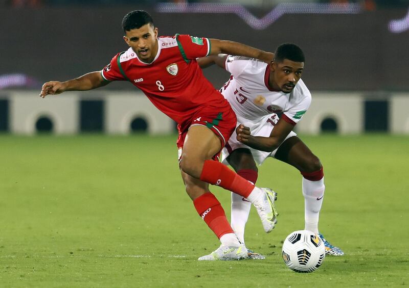 Oman's Abdullah Fawaz, left, in action against Qatar's Mosaab Khidir. The hosts qualified for the AFC Asian Cup 2023 after defeating Oman 1-0 .