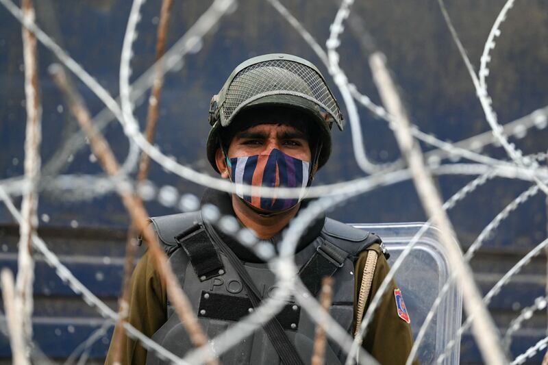 A security personnel at a road block during a nationwide strike called by farmers, along the Ghazipur New Delhi-Uttar Pradesh state border. AFP