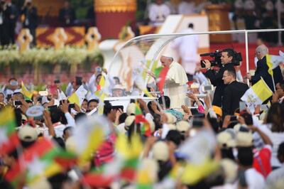 Pope Francis waves to Myanmar catholics prior to an open air mass in Yangon on November 29, 2017. - Pope Francis is to hold mass in Yangon with tens of thousands of Myanmar Catholics expected to pack into a stadium for the landmark event (Photo by Roberto SCHMIDT / AFP)