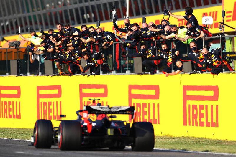 Rud Bull's Alexander Albon passes celebrating team members after securing third place and his first podium finish. Getty