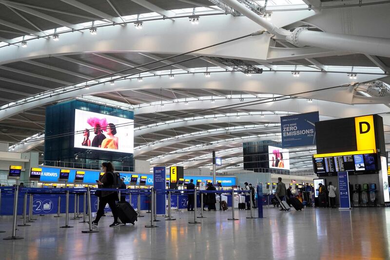 (FILES) In this file photo taken on December 21, 2020 Travellers wearing face coverings walk with their luggage in the almost deserted departures hall at Terminal 5 of Heathrow Airport in west London, as a string of countries around the world banned travellers arriving from the UK, due to the rapid spread of a new, more-infectious coronavirus strain.                          London's Heathrow airport dived into a net loss of £2.0 billion last year, a result that "underlines the devastating impact of Covid-19 on aviation", it said on February 24, 2021. The loss after tax, equivalent to $2.8 billion or 2.3 billion euros, reflected a 73-percent plunge in passenger numbers, Heathrow said in a statement.
 / AFP / Niklas HALLE'N
