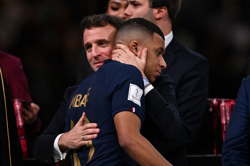 France's forward Kylian Mbappe is consoled by French President Emmanuel Macron after the World Cup final in Lusail on Sunday. AFP
