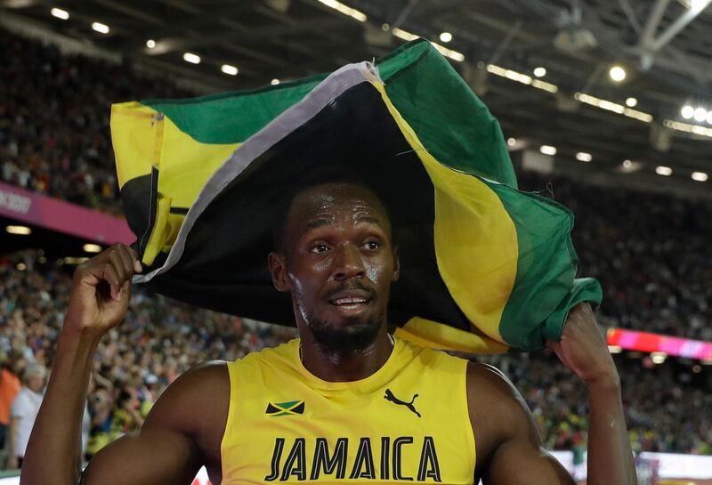 Jamaica's Usain Bolt celebrates with his national flag after placing third in the men's 100m final during the World Athletics Championships in London Saturday, Aug. 5, 2017. (AP Photo/Matthias Schrader)