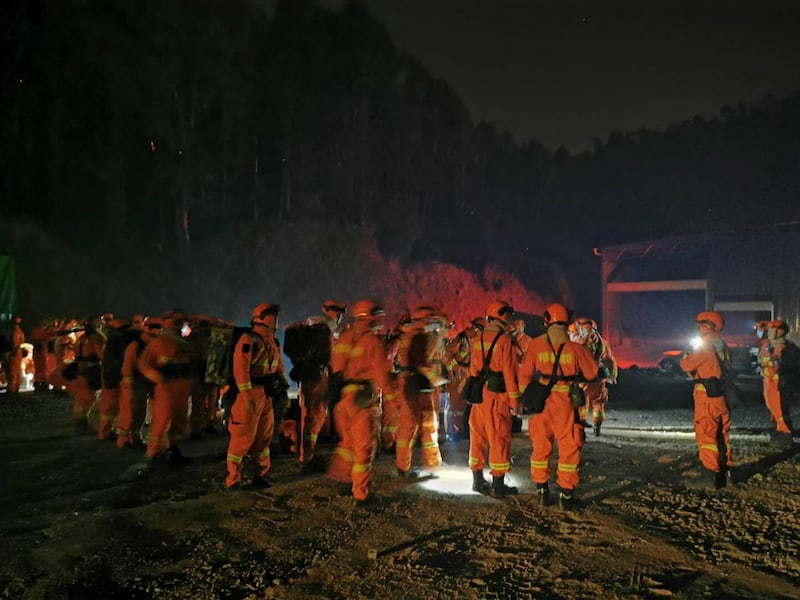 Firemen gather to put out a forest fire approaching a gas station in Xichang, Sichuan province.  EPA
